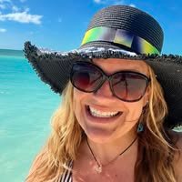 Brit Lynne smiling in front of a tropical beach